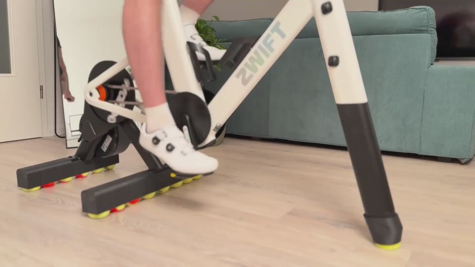 Zwift Ride smart frame on a Wahoo KICKR CORE 2 trainer moving naturally from side to side on ROCKERON rear adapters and a matching front support with colored motion balls.